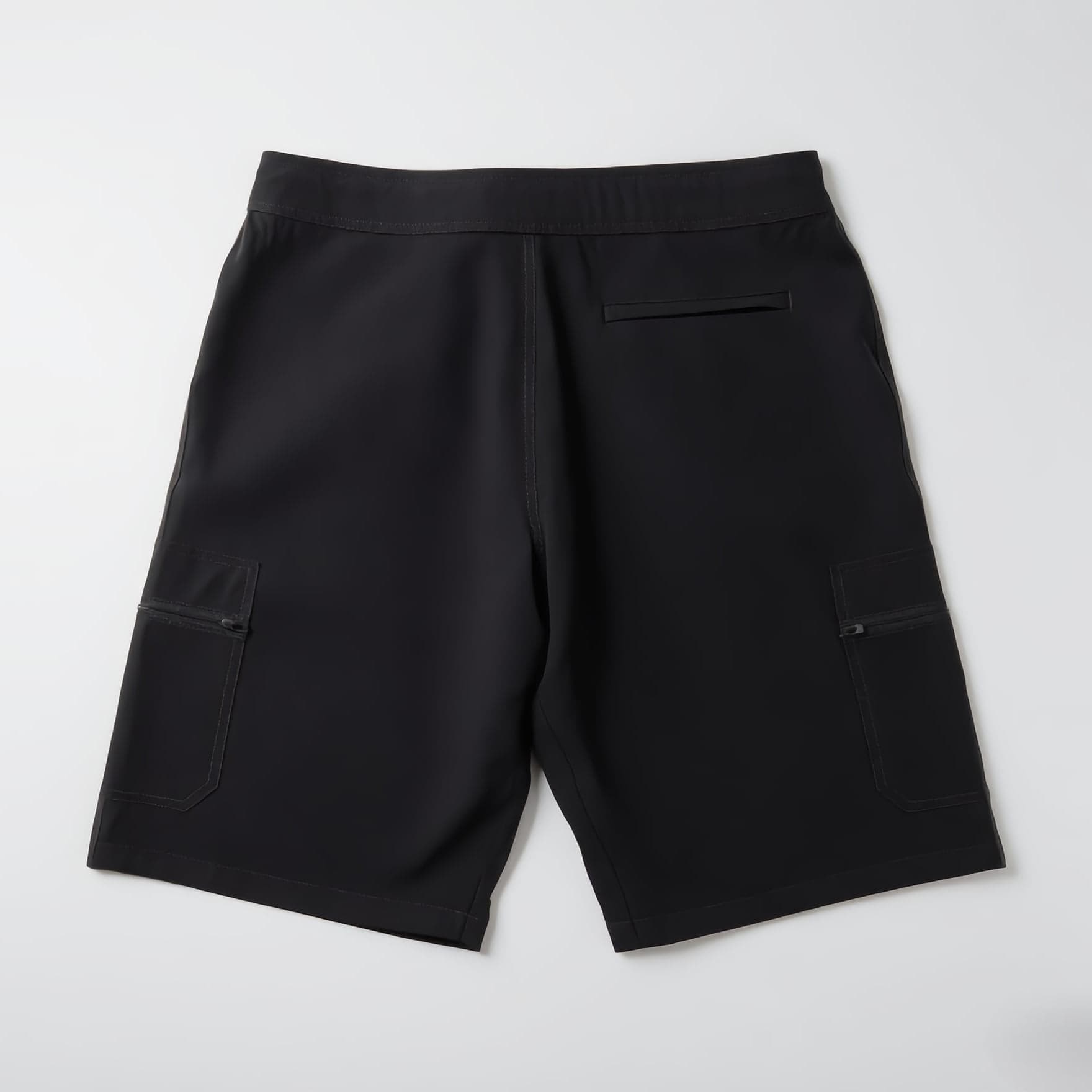 LODI Original Boardshort in Charcoal, laid flat, back view: welt pocket below the waistband and a flap pocket with a zip on each leg.